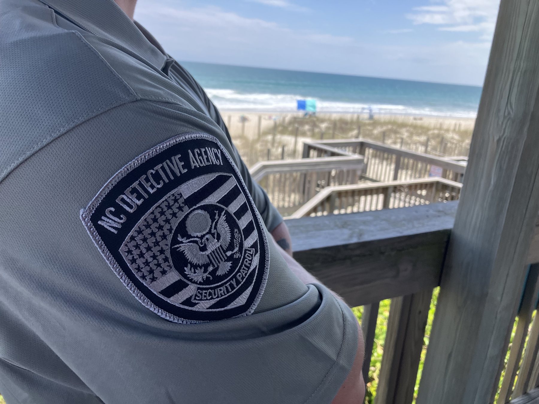 NC Detective Agency shoulder patch overlooking a North Carolina beach